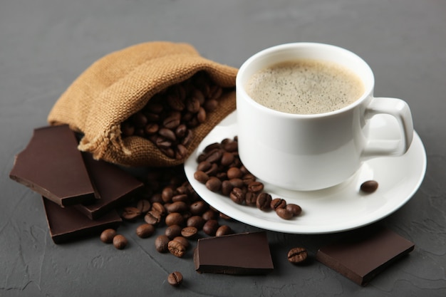 cup of coffee coffee beans and chocolate on the table close up