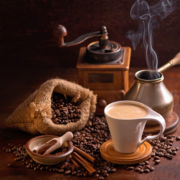 Cup of coffee and coffee beans in a sack on dark table, top view