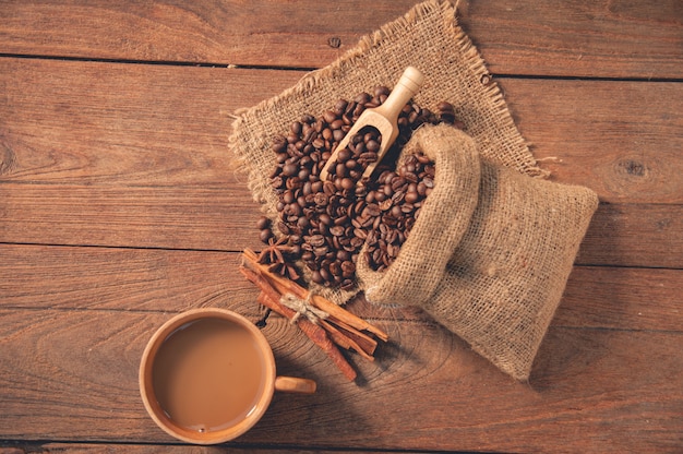 Cup of coffee and coffee beans on wooden table