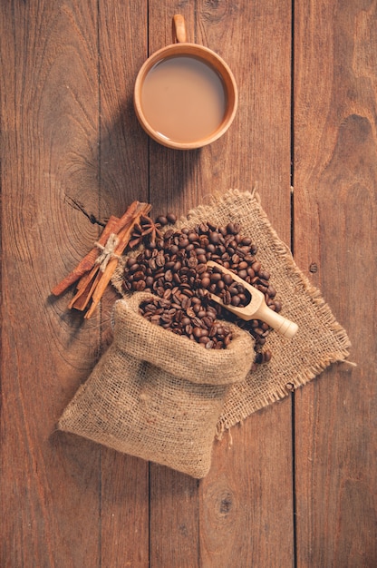 Cup of coffee and coffee beans on wooden table