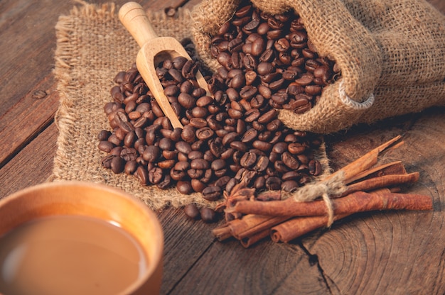 Cup of coffee and coffee beans on wooden table