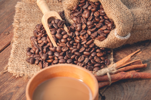 Cup of coffee and coffee beans on wooden table