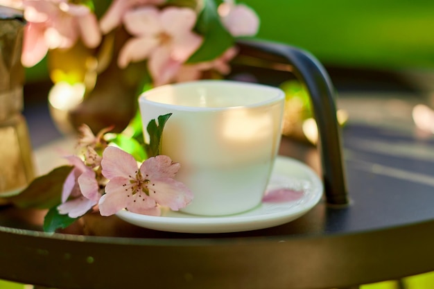 Cup of coffee flowers and notebook on the small black table