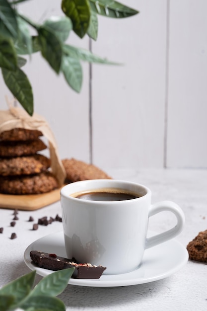 A cup of coffee in the foreground Selective focus Against the background of oatmeal cookies