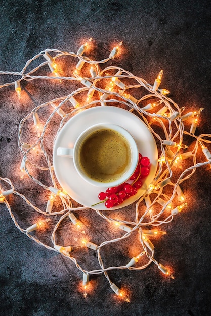 cup of coffee and a garland on a concrete background