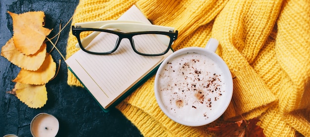 Cup of coffee, glasses and a bright yellow sweater