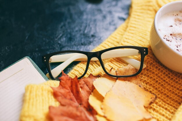 Cup of coffee, glasses and a bright yellow sweater