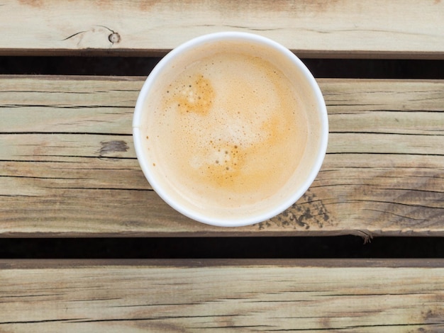 Cup of coffee to go on the wooden table Street coffee top view