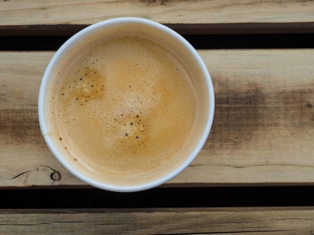 Cup of coffee to go on the wooden table Street coffee top view