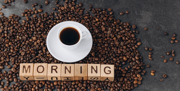 A cup of coffee and the inscription good morning on wooden cubes