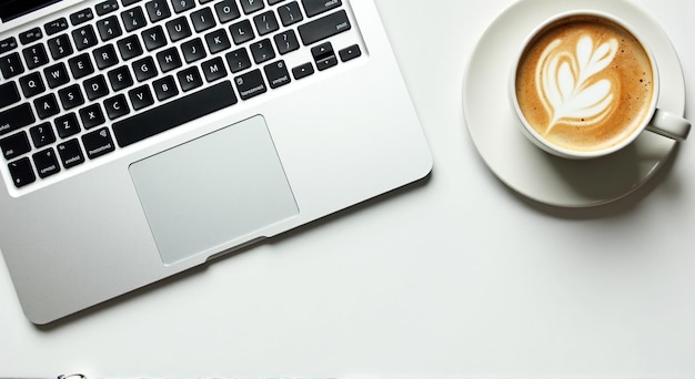 a cup of coffee next to a laptop with a cup of coffee