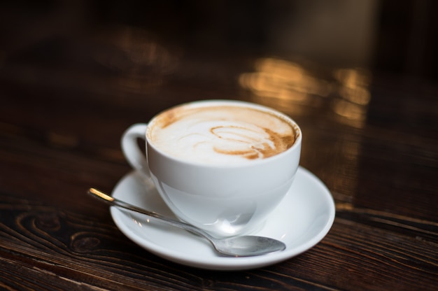 Cup of coffee latte on old wooden surface