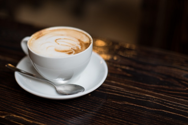 Cup of coffee latte on old wooden surface