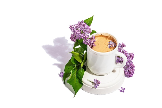 Cup of coffee and lilac flowers bouquet isolated on a white background Breakfast springtime concept