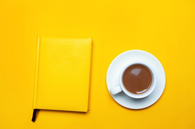 A cup of coffee and notebook.