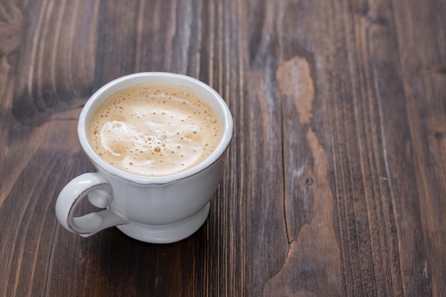 A cup of coffee on old wooden surface