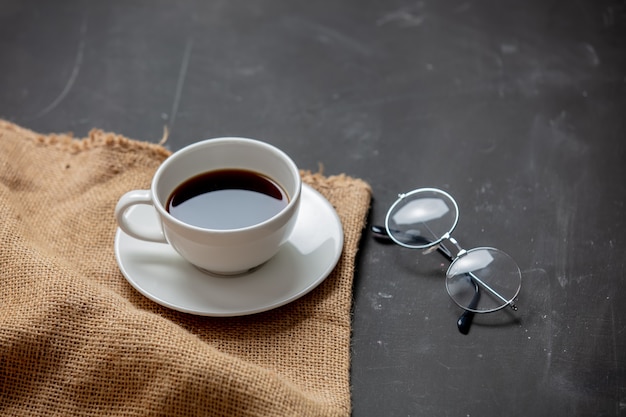 Cup of coffee and reading glasses