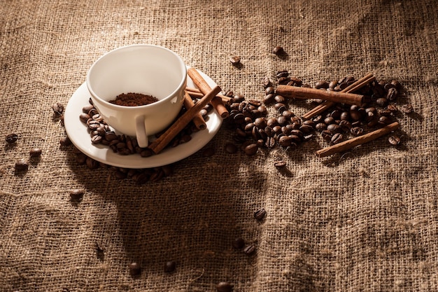 A cup of coffee on sackingcinnamon coffee beans