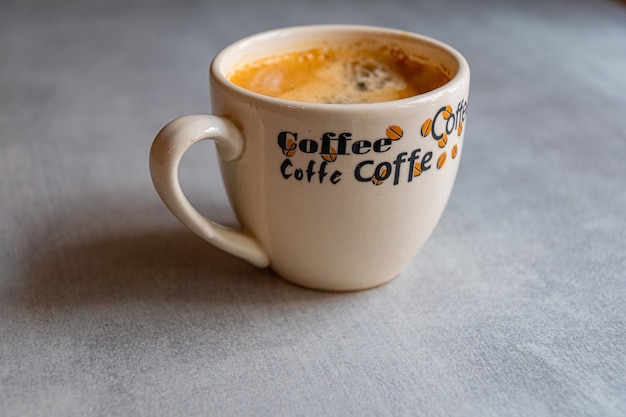 Photo cup of coffee on a saucer on a gray table