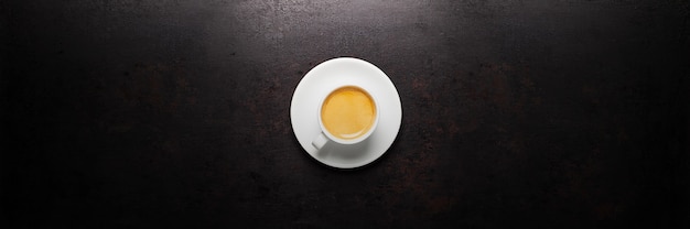 Cup of coffee standing on old rustic background. Banner layout