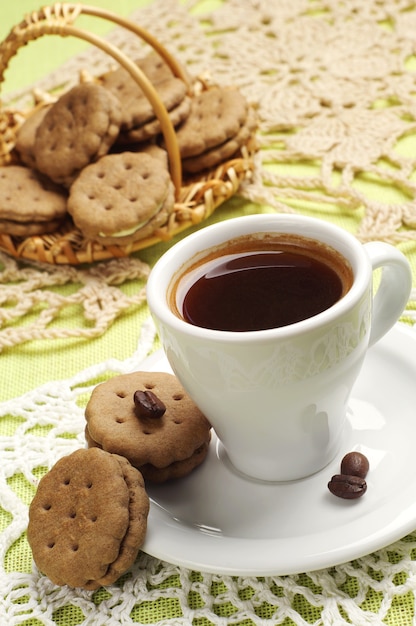 Cup of coffee and sweet cookies on a tablecloth