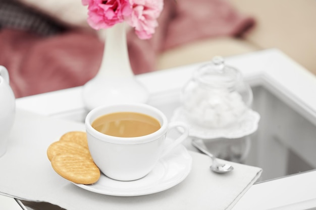 Cup of coffee on table in living room