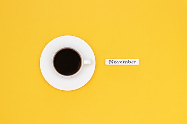 Cup of coffee and text NOVEMBER on yellow