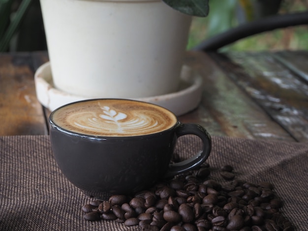 Cup of coffee with beautiful Latte art. Coffee cup with latte art on the wood table.