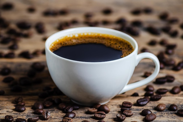 A cup of coffee with coffee bean on wooden background