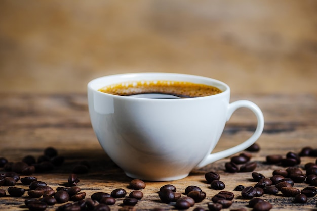 A cup of coffee with coffee bean on wooden background