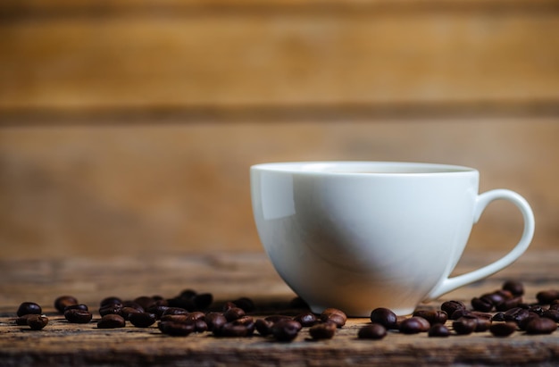 A cup of coffee with coffee bean on wooden background