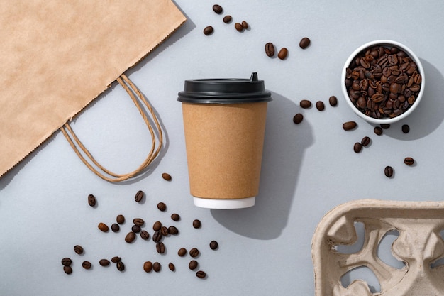 Cup of coffee with coffee beans on paper background top view