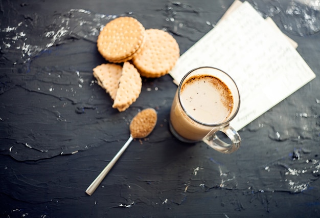 Cup of Coffee with a Cookies and brown shugarFreshly brewed cup of latte served with chocolate