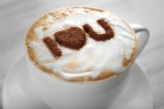 Cup of coffee with creative pattern on wooden table