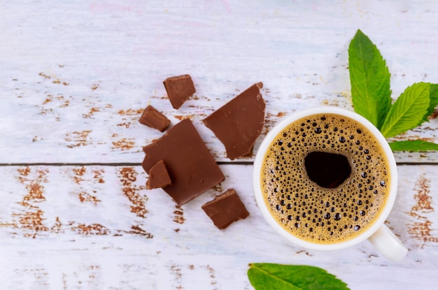 Cup of coffee with foam, mint and chocolete pieces