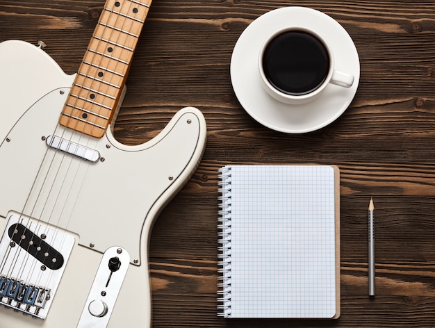 Cup of coffee with guitar and notebook