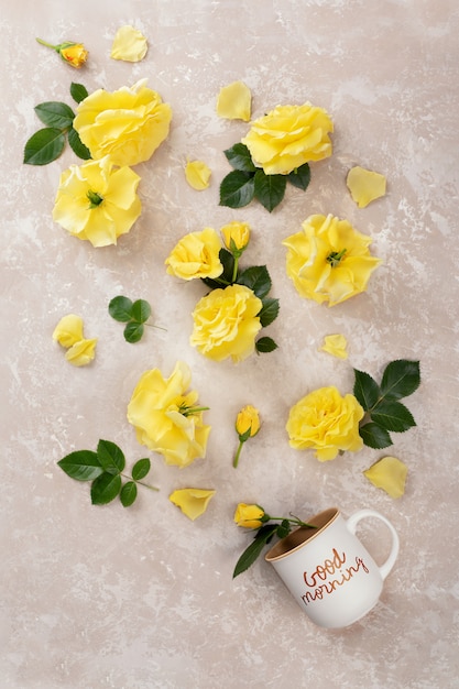 Cup of coffee with the inscription Good morning and yellow roses and leaves