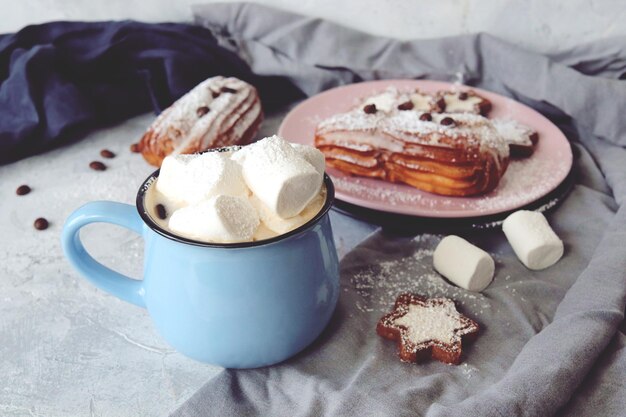 Cup of coffee with marshmallows eclairs and cookies coffee grains