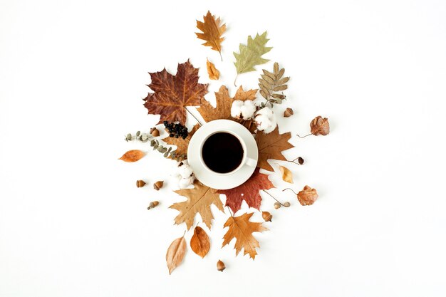 Cup of coffee with milk, cotton buds, acorns, dry leaves on white. Flat lay, top view