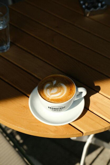 Photo a cup of coffee with the name latte on it sits on a table