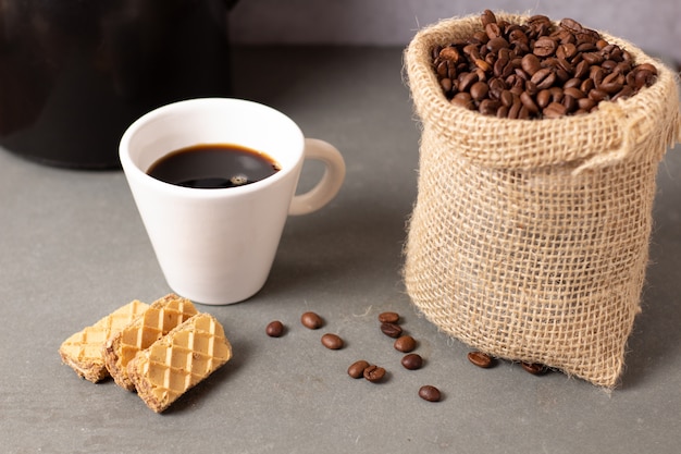 Cup of coffee with some cookies and coffee beans 