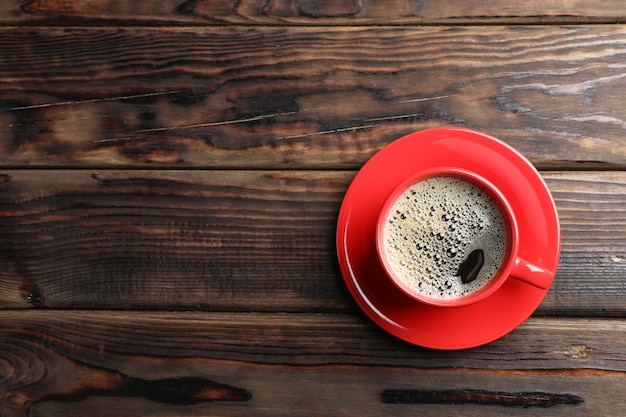 Cup of coffee on wooden background, top view