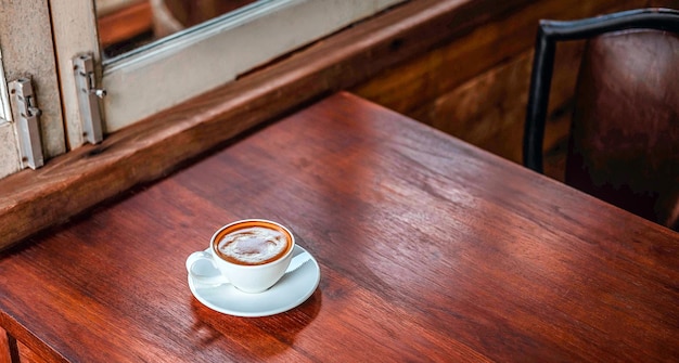 A cup of coffee on wooden table in coffee shop