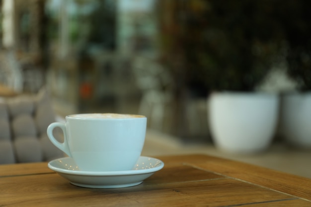 Cup of coffee on wooden table in restaurant