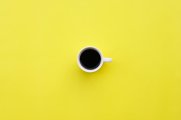 Cup of coffee on yellow background