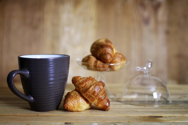 Photo cup croissant breakfast wooden background