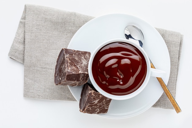 Cup of delicious thick drinkable hot chocolate with pure dark chocolate bars