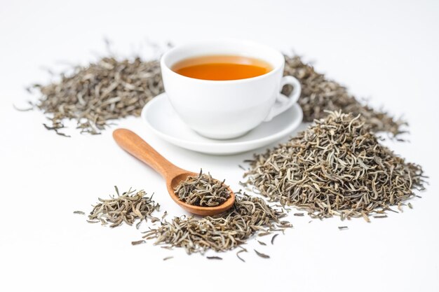 A cup of Dianhong tea next to dried tea leaves on the table