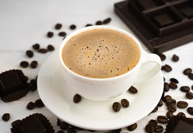 Cup of fresh coffee and and chocolates candies on a wooden table Closeup Selective focus