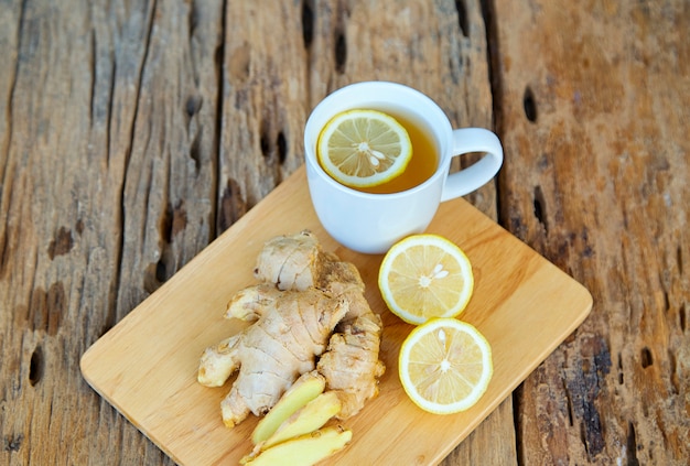 Cup of ginger tea with lemon on wooden